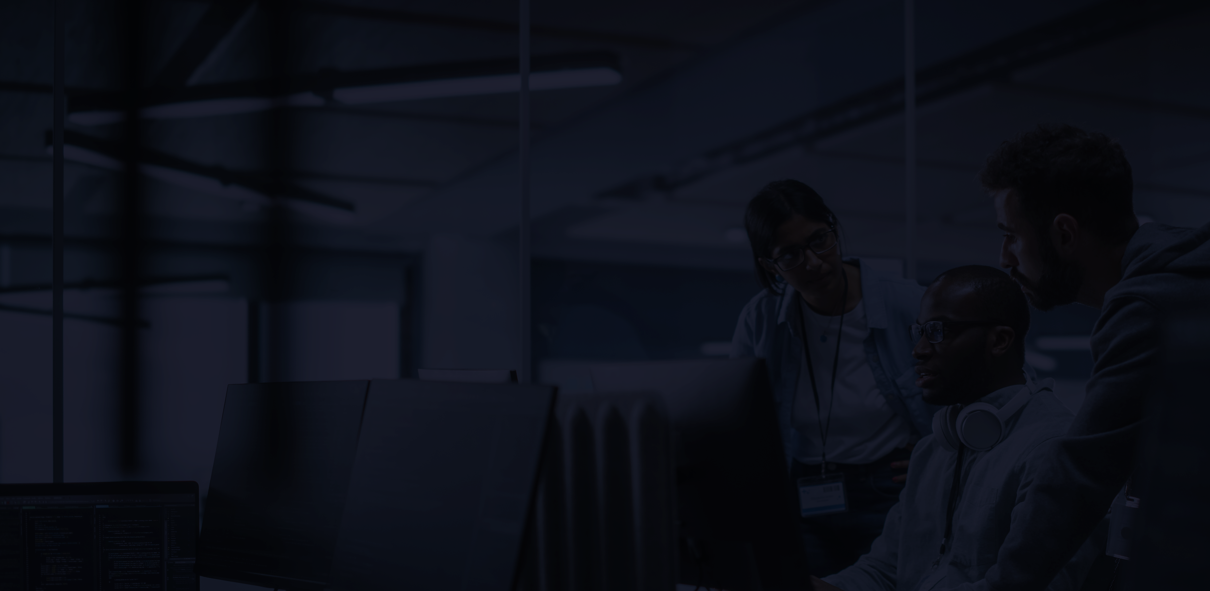 Three people around a computer